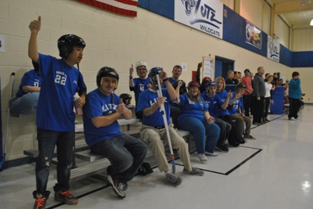 The Lutz hockey team and audience cheering and giving thumbs up from the bleachers.